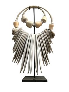 Handmade ceremonial Papua traditional Ornament from Indonesia. Made of white Shells . This Necklace is used in Papua for special rituals or ceremonies. Also is used as a payment between tribes. This beautiful piece is a very unique and powerful object in the Balinese culture. Size : Width 28 cm x 48 cm high Stature on its stand : 48 cm It can be wearied or used as a Decoration. You can buy with black metal stand You can buy without stand, you can hang it on the wall. White Shells, Necklace Traditional, Traditional Ornaments, Metal Stand, Ethnic Style, Balinese, Black Metal, Decorative Items, Shells