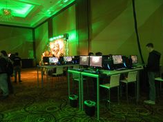 a room filled with lots of laptops on top of desks in front of green lights