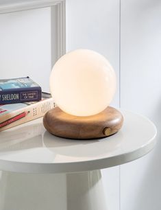 a table with a lamp on top of it next to some books and a book