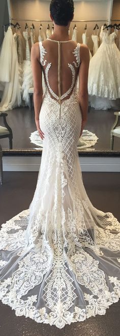 the back of a woman's wedding dress in front of a mirror