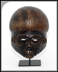 an african mask is displayed on a stand