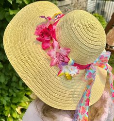 "Who's ready for the beach?  Do you have all the appropriate beach gear you'll need when summer rolls around?  How about a fun beach hat, more specifically, a fun beach hat that reminds you of being at a tropical island?  This woven straw sun hats has a wide, floppy brim and 22\" circumference to fit nearly all adults.  The sun hat is breathable and keeps the sun's glare at bay, making it perfectly comfortable to wear outdoors in the summer, gardening or hosting backyard parties. Use the floppy sun hat as table decor that guests can take with them!  Relax in style this summer by protecting your skin and looking fabulous.  An orchid-print and rainbow lace ribbons, bow and tropical orchids adding a wonderful touch! Start getting yourself beach ready with this adult floppy beach hat!" Adjustable Straw Hat For Poolside Beachwear, Summer Hats For Sunbathing And Beach Season, Sun Straw Hat For Beach Vacation, Vacation Sun Hat With Uv Protection For Poolside, Beach Vacation Sun Straw Hat, Beachy Hats With Uv Protection For Beach Season, Beach Season Straw Hat, Vacation Beach Sun Straw Hat, Vacation Hat With Uv Protection