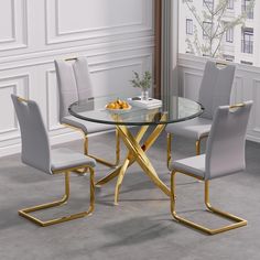 a glass table with four chairs around it in a white and gold dining room setting