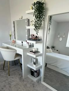 a bedroom with a bed, desk and mirror in it's corner next to a plant