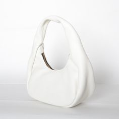 Crafted from buttery soft Italian leather, this shoulder bag features curved silhouette that rests comfortable under your arm. Petite in size, it has more than enough room for all your daily essentials. Shoulder bag with zip closure Fully lined interior 11in Wide x 12in High x 4in Deep Italian Buffalo Leather Made in USA White Leather Hobo Bag With Zipper Closure, Leather Tote Baguette Bag With Zipper Pocket, Leather Baguette Bag With Zipper Pocket, Leather Baguette Bag With Round Handle For Everyday, Chic Daily Use Baguette Bag With Smooth Grain, Chic Daily Use Smooth Grain Baguette Bag, Modern Soft Leather Baguette Bag For Errands, Everyday Textured Leather Shoulder Bag With Round Handle, Daily Use Baguette Shoulder Bag With Smooth Grain