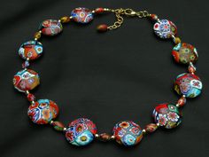 a multicolored glass beaded necklace on a black background