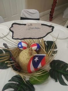 a table topped with a basket filled with balls and palm leaves next to a sign