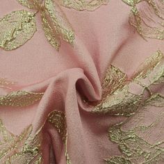 pink and gold brocaded fabric with large leaves on the side, closeup