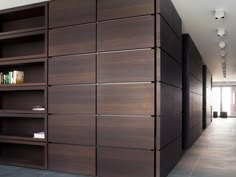 an empty room with bookshelves in the middle and tile flooring on the other side