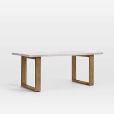 a white table with wooden legs and a square shaped design on the top, against a gray background