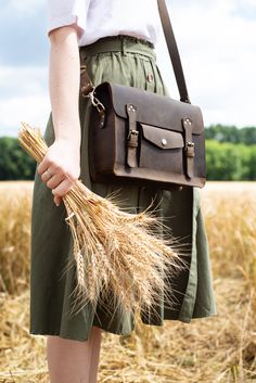 "This leather satchel manifests efficient storage, carrying comfort, and vintage elegance. Just right in size, this versatile leather briefcase holds as much as you need without looking bulky. Small internal and external pockets offer an apt spot for keeping essentials secured and organized. A detachable, adjustable shoulder strap and optional top handle allow you to wear it whichever suits your active lifestyle. Safe, neat belt buckles and patinaed leather bring a final touch of fine vintage.sa Chocolate Gold, Leather Satchel Handbags, Espresso Brown, Model Features, Dark Brown Color, Leather Laptop, Leather Messenger Bag, Leather Briefcase, Satchel Purse