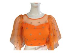 Step into elegance with our Orange Color Netted Party Wear Readymade Saree Blouse. This Indian Designer Blouse seamlessly blends tradition and style, perfect for your special occasions. Shop now and enhance your saree ensemble effortlessly! * This Is A Fully Stitched Saree Readymade Blouse, that can be worn with any saree. * Made Of High-quality Netted Fabrics, Lined With Crape Silk * Opens From Back With Hook And Eye Fitting * Purely Handmade Designs * Color may slightly vary due to digital pho Traditional Tops With Sheer Dupatta, Traditional Tops With Sheer Dupatta Drape, Traditional Drape Georgette Tops For Eid, Festive Blouse With Sheer Dupatta For Eid, Festive Celebration Blouse With Sheer Dupatta, Traditional Festive Tops With Sheer Dupatta, Traditional Drape Georgette Top For Diwali, Diwali Traditional Drape Georgette Top, Blouse With Sheer Dupatta For Celebrations