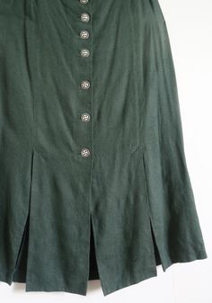 Vintage long Austrian/German folk skirt by Alphorn.  Pine green linen blend: 65 % linen, 35 % viscose/ rayon. A-line silhouette, gored style, ornate metal buttons down the front.  There are four slits in the bottom: two in the front and two in the back. Acetate lining. Got elastic inserts in the waist sides. Size on the tag European 44. Estimated Large. Please check the measurements: waist  ~ 86 - 92 cm  /  ~ 34 - 36 " length  ~ 86 cm  /  ~ 34 " In great vintage condition. Still got a spare button. Green Dirndl, Folk Skirt, Buttoned Skirt, German Folk, Skirt Linen, Peasant Skirt, Rock Vintage, Vintage Rock, Viscose Rayon