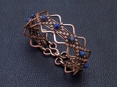 Handmade serpentine wire wrapped copper and 4 mm tiny Lapis  lazuli gemstones women weaved bracelet . September birthstone perfect gift for virgo sign girlfriend , unique and special gift for wife for 7th copper wedding anniversary . Bracelet width : 2 cm - 0.8" Copper is oxidized to give it an antique appearance. Please read about copper care on Info & Faq section. The requested piece it's made to order similar with the original shown item . Please be sure to read the entire description of the Elegant Hand Wrapped Jewelry With Round Beads, Adjustable Metal Jewelry With Round Beads, Metal Bracelet Jewelry For Gifts, Metal Bracelet Jewelry Gift, Wire Wrapped Round Jewelry For Gifts, Wire Wrapped Round Jewelry As Gift, Handmade Metal Jewelry With Round Beads, Wire Wrapped Jewelry As A Gift, Hand Wrapped Metal Bracelets