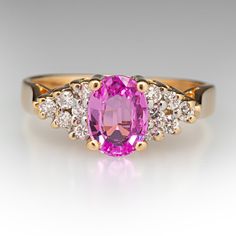 This sweet ring is centered with an oval cut pink sapphire, weighing 1.00 carat, in a four-prong setting. The shoulders are each bead set with six (6) round brilliant cut diamonds. The ring measures 6.9mm at the top, rises 6.3mm above the finger, tapering to 2.0mm wide and 0.7mm thick at the base of the shank. The ring currently fits a size 4.75. Pink Diamond Accented Fine Jewelry For Wedding, Pink Classic Diamond Promise Ring, Classic Pink Ruby Ring For Anniversary, Luxury Yellow Gold Diamond Ring With Pink Sapphire, Pink Oval Diamond Ring, Pink Sapphire Ring With Diamond Accents For Anniversary, Classic Pink Diamond Ring With Round Cut, Classic Pink Sapphire Ring For Anniversary, Classic Pink Round Cut Diamond Ring