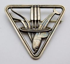 We offer a wonderful Georg Jensen Sterling Silver Brooch/Pin in the scarce pattern number 257. This a wonderful Art Deco piece that was designed by Arno Malinowski in the 1930's and is consists of a diving Dolphin with cattails in a triangular frame. This lovely piece is in superb condition, the sturdy rollover pin is secure and will prevent loss. As the photos demonstrate, this lovely piece has a slight patina. The Brooch measures 1 5/8's inches on each side and weighs approx. 11 grams. We beli Collectible Art Nouveau Hallmarked Brooch, Modernist Silver Jewelry, Georg Jensen Jewelry, Bijoux Art Deco, Lapel Brooch, Silver Brooch Pin, Modernist Jewelry, Sterling Silver Brooch, Georg Jensen