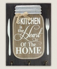 a wooden sign that says kitchen is the heart of the home with utensils