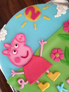 a peppa pig cake with flowers and clouds on it