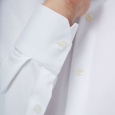 The James solid OoohCotton shirt features a point collar, adjustable notched cuffs, mother-of-pearl buttons, and a curved hem perfect for wearing tucked or untucked. OoohCotton is a performance, double-mercerized, wrinkle-resistant, breathable, and easy-care cotton blend with 8-way stretch, quick-dry, and thermal comfort properties. White Business Blouse With Placket, Classic White Blouse With Hidden Buttons, Classic White Blouse With Hidden Button Closure, White Blouse With Placket For Business, White Blouse With Concealed Placket And Fold-down Collar, Classic Collared Shirt With Cuffed Sleeves, Timeless Long Sleeve Dress Shirt With Button Cuffs, Classic White Blouse With Concealed Placket, Classic Tops With Cuffed Sleeves And Spread Collar