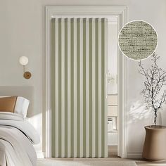 a bed room with a neatly made bed and a striped curtain in front of the door