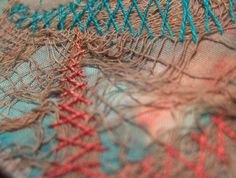 there is a piece of fabric with red and blue thread on it that has been stitched together