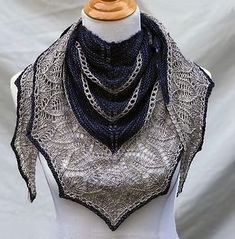 a white mannequin wearing a black and gray shawl on top of it