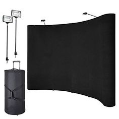 a black backdrop with two lights and a bag on the ground next to it's side