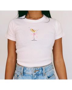 Martini Baby Tee   Women's T-Shirt | Girly Aesthetic | Y2K Trendy Shirt 🌟SHIRT This is a Bella+Canvas baby tee - the material is very soft and very high quality. 🌟SIZING Please find the size chart in listing photo before purchasing. We recommended measuring a t-shirt you already own to get the best fitting t-shirt. 💖CARE/ WASH Machine wash: warm (max 40C or 105F); Non-chlorine: bleach as needed Tumble dry: medium heat; Iron, steam or dry: low heat; Do not dry clean. ✨SHIPPING Your items usual Fitted Basic T-shirt With Funny Print, Cute Fitted Summer T-shirt, Pink Fitted Graphic Tee, Fitted Pink Graphic Tee Shirt, Cute Fitted Shirt With Graphic Print, Fitted Cute Shirt With Graphic Print, Fitted Shirt With Graphic Print In Cute Style, Cute Short Sleeve Tops With Funny Print, Cute Crew Neck Top With Funny Print