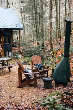 two adiron chairs and a fire place in the woods