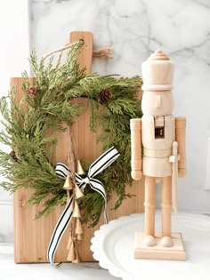 a wooden toy standing next to a christmas wreath