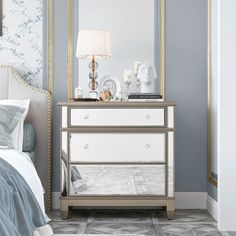 a bedroom scene with focus on the dresser and mirror, which has been decorated in blue and white