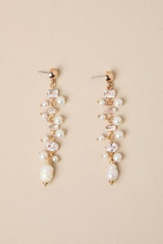 two pairs of pearl and crystal earrings on top of a white surface with gold accents