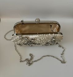 The Pearl Purse is a stylish blend of sophistication and glamour. It is crafted with precision and attention to details. This beaded purse is a must have addition to your accessory collection. It will glamorize your look and is spacious enough to carry all the essentials. The clutch comes with a detachable chain strap so you can carry it as a clutch or a shoulder & crossbody bag. Dimensions: (LxHxW): 7.5 inches x 4.7 inches x 1.97 inches Material: Pearls and Beads, Satin, Rhinestones Features: K Chic Pearl Clutch For Formal Occasions, Elegant Luxury Shoulder Bag, Elegant Clutch Shoulder Bag As Fashion Accessory, Luxury Pearl Clutch For Formal Occasions, Chic Pearl Clutch For Party, Elegant Handheld Beaded Evening Bag, Luxury Pearl Clutch For Events, Luxury Pearl Clutch For Party, Luxury Pearl Evening Bag For Party