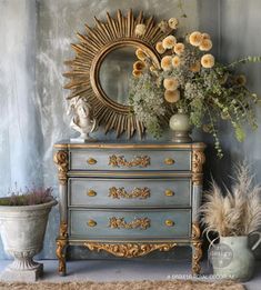 an antique dresser with flowers and plants on top