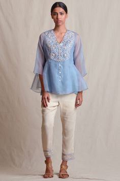 Powder blue floral motif adorned tunic with crepe inner.
Components: 1
Work: Resham Thread,Cutdana Embroidery
Neckline: V Neckline
Color: Blue
Fabric: Organza,Crepe
Sleeve: Three Quarter Sleeves
Other Details: 
Front Loop Button Closure
Note: Pant worn by the model is not for sale - Aza Fashions Elegant V-neck Top With Chikankari Embroidery, Blue Georgette Blouse Piece With Floral Embroidery, Silk V-neck Top With Embroidery, Elegant Embroidered Top With Sleeves For Summer, Elegant Summer Top With Embroidered Sleeves, Elegant Summer Embroidered Top With Sleeves, Fitted Chikankari Embroidery Straight Kurta Top, Fitted Straight Kurta With Chikankari Embroidery, Elegant V-neck Tops With Chikankari Embroidery