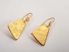 Hammered triangle drop earrings in bohemian style. Lightweight and perfect for everyday wear.  A unique and original form to bring personality and a little sparkle to your ears!  Perfect as a gift for yourself or for a loved one!  Specifications: ◈ Each triangle is 10-16mm (0.39-0.62 inches) in diameter ◈ Each earring measures 16mm (0.62 inches) wide by 35mm (1.37 inches) long.  ◈ Weight: about 5g  ◈ Material: Solid 14k gold  ◈ Nickel free. ◈ All earrings with French ear wires come with silicon backings for extra protection. In case of custom orders - please contact us for pricing. ◈ SHIPPING is insured express and free worldwide ◈ GIFT WRAPPING is included with every purchase ✧ Looking for more unique and beautiful wedding bands: https://etsy.me/32OIpT5  ✧ Back to my shop for more handcra Gold Triangle Jewelry With Ear Wire, Triangle Yellow Gold Earrings For Gift, Handmade Gold Triangle Jewelry, Bohemian Gold Triangle Jewelry, Gold Schmuck, Beautiful Wedding Bands, Gold Triangle, Gold Earrings For Women, Hammered Gold