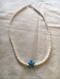 "A white shell necklaces with a blue glass starfish charm.  The necklace is 18\" in length.  The price includes priority shipping with insurance." White Starfish Jewelry For Vacation, Handmade Starfish Shell Necklace For Vacation, Blue Shell Necklace For Vacation, White Jewelry With Starfish Charm For Vacation, Starfish Shell Necklace For Vacation, White Beaded Necklaces With Starfish Charm For Beach, White Necklace With Starfish Charm For Vacation, Ocean-inspired White Star Jewelry, White Starfish Shell Necklace As A Gift