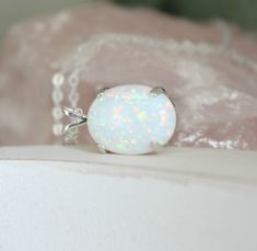 "Beautiful Large white lab-created opal pendant necklace. These gorgeous opals are very similar to natural mined opals. Lab-created opals contain 70-90% silica (from which natural opal is formed) and 10-30% resin. The resin makes the opal harder, stronger, unlike natural opals, which are known to be soft and fragile. Each opal displays a rainbow of color that sparkles with every catch of light. I've handset two different size opals in a solid sterling silver prong settings 16x12mm (5/8\" x 1/2\" White Opal Jewelry Gift, White Opal Gemstone Necklace, White Opal Round Pendant Necklace, White Opal Pendant Jewelry, White Opal Birthstone Jewelry, White Oval Opal Necklace, White Opal Necklace For Gift, Elegant White Pink Opal Jewelry, White Pink Opal Gemstone Jewelry