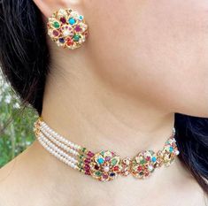 Featuring a navratna choker in 22ct gold with studs earrings. The choker weighs 30.98 GMs including 8 GMs of stringing beads. The earrings weigh 11.35 GMs Navratna Choker, Jadau Choker, Jadau Jwellery, 22k Gold Jewelry Necklaces, Stringing Beads, 22k Gold Jewelry, Kurti Neck, Antique Bridal Jewelry, Pearl Necklace Set