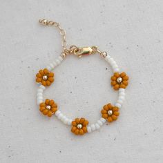 Our daisy chain beaded bracelets can be personalised with an initial or symbol disc add on. They are the sweetest keepsake jewellery for your little ones. Lovingly hand beaded using only high quality seed beads. Suitable for kids aged 3+ years old. Metal hardware options : 14k Gold filled, 14k Rose gold filled or Sterling Silver. Each bracelet comes with an extra 0.5" extension chain so your little one can still wear their bracelet as they get older. Handcrafted in Australia. Each piece is hand Adjustable Beaded Bracelets With Flower Charm For Jewelry Making, White Daisy Bracelets As Gift, Cute Adjustable Gold Beaded Necklace, Adjustable Dainty Beaded Bracelets For Birthday, Dainty Adjustable Beaded Bracelets For Birthday, Everyday Beaded Flower Jewelry, Cute White Beads For Gifts, Cute White Beads As Gift, Everyday Flower Shaped Beaded Jewelry