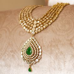 An heirloom of divinity, crafted through the ages! Introducing an opulent fiver-layer kundan mala, adorned with a magnificent emerald stone centerpiece that exudes timeless elegance, this set blends the regal charm of kundan with the vibrant allure of emeralds. A masterpiece of craftsmanship, it promises to elevate any occasion with its majestic allure. The listing includes long mala and a pair of matching earrings. Gold-plated on high-quality brass as base metal. Made by order. Kindly allow 5-7 Elegant Hand Set Kundan Necklace For Rituals, Elegant Kundan Jewelry For Rituals, Diwali Kundan Necklace For Rituals, Elegant Kundan Necklace For Rituals, Festive Kundan Emerald Necklace With Intricate Design, Emerald Temple Jewelry Bridal Necklace, Kundan Gemstone Necklace For Puja In Temple Jewelry Style, Elegant Kundan Necklace With Meenakari For Puja, Green Kundan Necklace For Diwali Rituals