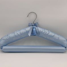 a baby blue suit hanger with a bow on it