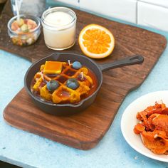 a pan filled with food sitting on top of a wooden cutting board next to an orange slice