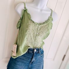 Shyanne Green Sage & Gold Sequin Strappy Lettuce Edge Embroidered Blouse Sz Xs. This Adorable Strappy Tank Top Is Just The Right Amount Of Summer And Shimmer! Features Adjustable Straps And Spare Sequins. The Embroidery Detail On This Blouse Is Beautiful! Pairs Well With Jeans And Boots/Sandals. Measures 19 1/2” Pit To Pit 23” In Length (Adjustable Straps!) Comes From A Smoke-Free, Doggo Loving Home :) Spring Cotton Lace Top With V-neck, Spring Lace Trim Camisole, Feminine Summer Lace Top With Floral Embroidery, Green Embroidered V-neck Top, Spring Cami Tops With Lace Trim, Spring Camisole Top With Lace Trim, Spring Lace Trim Camisole Top, Summer Cotton Lace Top For Vacation, Fitted Floral Embroidered Camisole For Summer