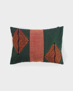 an orange and green decorative pillow on a white background, with the same pattern as the rest of the pillow