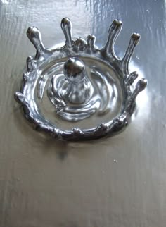 a metal bowl with water in it on a table