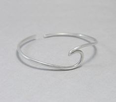 Wave cuff bangle, sterling silver, beach jewellery, ocean, beach bracelet, minimalist, adjustable, gift for her, one size Sterling silver solid cuff hand formed to a wave shape from 12 gauge (2 mm) wire. Comfortable to wear all day or sleep with and sturdy. This bangle is slightly adjustable and thus one size. It will fit most wrists (14 -18 cm / 5.5 - 7 inches wrist). But you can always ask for a different size. The bracelet above is not the exact one you will receive. Each one is handmade to o Adjustable Silver Bracelets With Ocean-inspired Style, Adjustable Silver Bracelet With Ocean-inspired Style, Adjustable Silver Ocean-inspired Bracelets, Silver Adjustable Ocean-inspired Bracelets, Silver Minimalist Bracelets For The Beach, Adjustable Ocean-inspired Jewelry For Everyday, Everyday Adjustable Ocean-inspired Jewelry, Adjustable Ocean-inspired Everyday Jewelry, Minimalist Beach Bracelet Jewelry