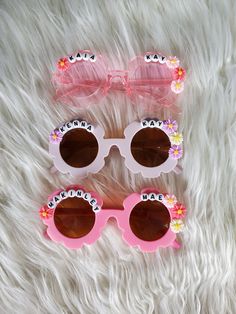 How adorable are these personalized sunnies!? Perfect for the summer sun! These custom sunglasses make the perfect gift or grab a pair for your little one! Each pair is handmade. Approx 5in wide across front of glasses Each pair will have personalized name you enter and decorated with flowers like shown in the pictures.  Please double check spelling. Cute Customizable Sunglasses For Gift, Custom Name Sunglasses For Summer Beach, Custom Name Pink Sunglasses With Adjustable Fit, Custom Name Sunglasses For Beach In Summer, Pink Sunglasses With Custom Name And Adjustable Fit, Customizable White Adjustable Sunglasses, Personalized Pink Sunglasses As A Gift, Pink Personalized Sunglasses For Gift, Personalized Sunglasses For Beach