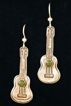 a pair of gold earrings with green beads