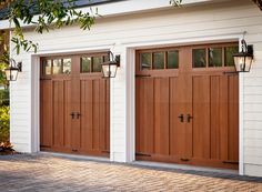 two brown garage doors in front of a white house